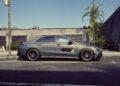 A matte grey 2026 Mercedes-AMG CLA 45 S Final Edition is parked on a street beside a building and a palm tree, viewed from the side.
