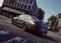 A matte gray 2026 Mercedes-AMG CLA 45 S Final Edition sedan with a rear spoiler cruises through a city street, passing modern buildings and palm trees.
