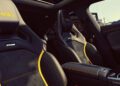 Interior of the 2026 Mercedes-AMG CLA 45 S Final Edition featuring black Alcantara seats with yellow accents, visible "RS" logos, center console, and a panoramic sunroof.