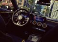 Interior view of the unveiled 2026 Mercedes-AMG CLA 45 S Final Edition, showcasing the modern steering wheel, dashboard, and infotainment system, with city buildings visible through the windshield.