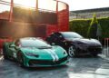 A green Ferrari F80 sports car with white racing stripes and the number 25 is parked next to a black Ferrari SUV on a paved lot under sunlight, reminiscent of a scene from Goodwood.