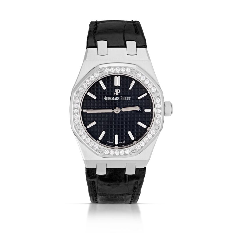 A luxury wristwatch with a black leather strap, silver case, diamond bezel, and black textured dial proudly displaying the Audemars Piguet logo—an exquisite choice among the best luxury watches.
