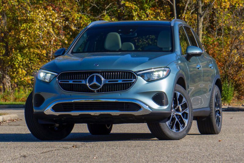 A silver Mercedes-Benz SUV, parked on a paved road framed by autumn foliage, showcases what you might find in the best car lease deals available this season.