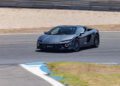 A gray Lamborghini Temerario makes a dynamic debut on the track, rounding a curve with a blurred background that emphasizes its thrilling speed.