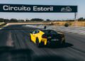 A yellow Lamborghini Temerario makes its dynamic debut on track at Circuito Estoril, passing under a sign with the circuit’s name.