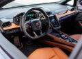 Interior of the Lamborghini Temerario sports car featuring a leather steering wheel, digital dashboard, touchscreen controls, and tan leather seats—designed for those who crave luxury and performance after a thrilling track review.