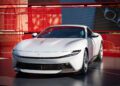 A white Ferrari F80 Hillclimb is displayed on a platform in front of a striking red backdrop at Goodwood.