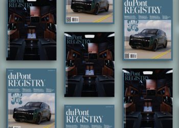 Multiple copies of the August 2025 duPont REGISTRY magazine, featuring a green luxury SUV and its upscale interior on the covers, are artfully arranged on a light blue background.