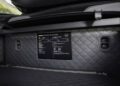 Close-up of a car trunk interior featuring quilted upholstery and a "Masterpiece Specifications" plaque, highlighting the premium detailing found in the BRABUS AMG GT.
