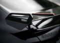 Close-up of a BRABUS-branded rear spoiler on a black AMG GT, highlighting the carbon fiber texture and striking red accent detail.