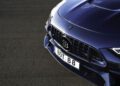 Close-up of the front grille and hood of a Deep Blue BRABUS car with a "B" logo and a license plate reading "BOT B 8" on a paved surface.