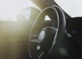 Close-up view of a BRABUS steering wheel and dashboard interior with sunlight streaming through the window, showcasing the elite craftsmanship of the Rocket GTS.