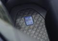 Close-up of a car's perforated leather seat in Deep Blue, showcasing a BRABUS MASTERPIECE plaque with signature and metallic blue trim, as seen in the exclusive BRABUS Rocket GTS.