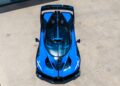 A top-down view of a blue sports car with black accents, parked on a concrete surface. This rare sight showcases the #001 of 40 Track-Only Bugatti Bolide set for auction debut at Pebble Beach.
