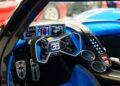 Close-up of a #001 of 40 Track-Only Bugatti Bolide cockpit, featuring a digital dashboard, flat-bottom steering wheel with the Bugatti logo, and blue interior trim—set for auction debut at Pebble Beach.