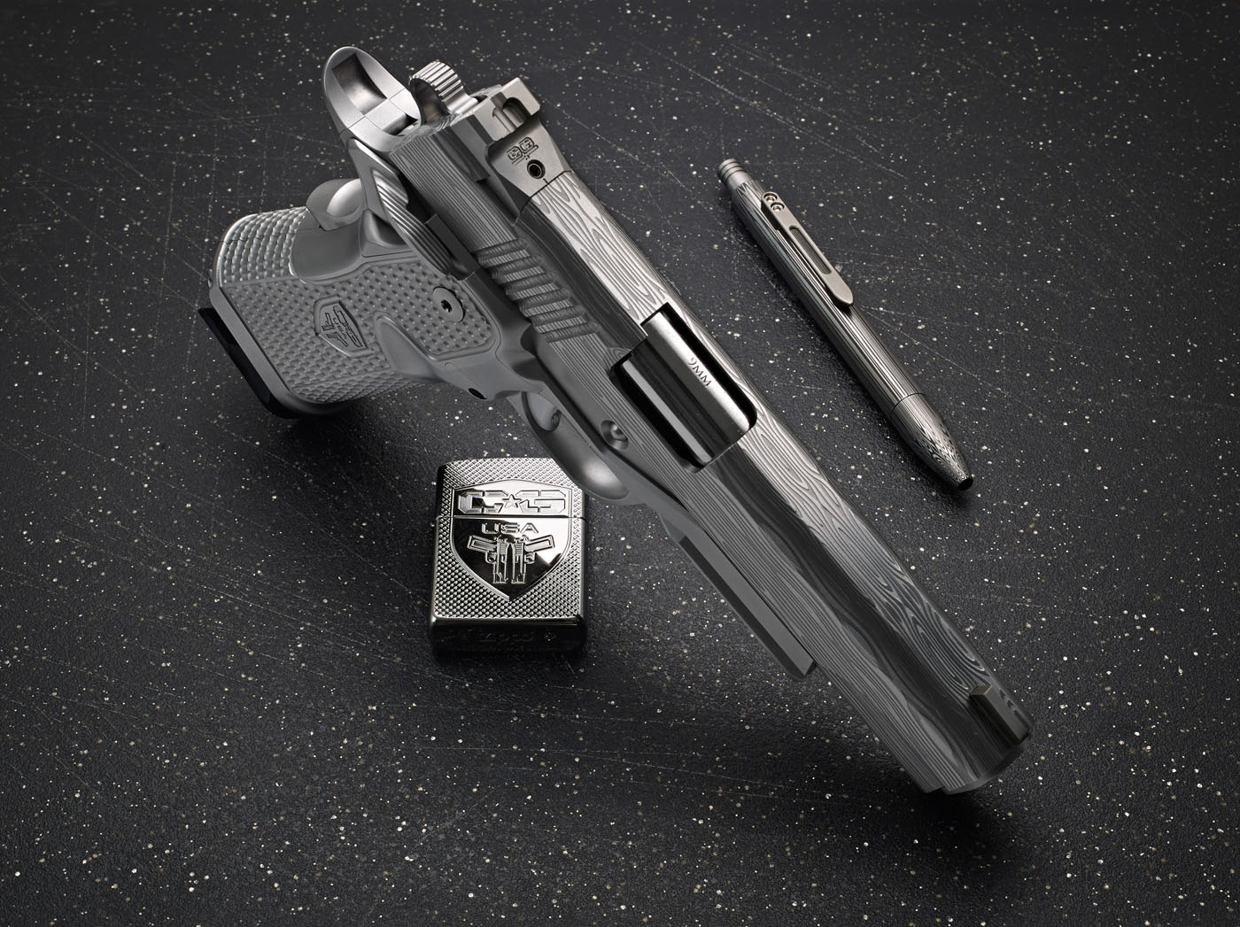 A silver pistol from Cabot Guns, a metal lighter with an engraved design, and a metallic pen are arranged on a speckled black surface, evoking a sense of enduring legacy.