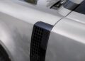 Close-up view of a Defender's front fender, highlighting design updates like the black vent detail, with part of the hood and front door also visible.