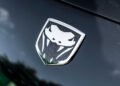 Close-up of a Dodge Viper emblem featuring a stylized snake head on a black textured background—Bid On This 2010 Dodge Viper SRT-10 Roadster ACR With Just 20 Miles for a rare opportunity to own an icon.
