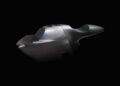 A matte black motorcycle fairing is displayed against a solid black background, resembling a futuristic aluminum sculpture.