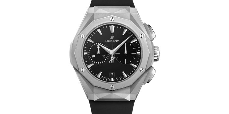 A silver Hublot wristwatch with a black dial, geometric bezel, chronograph subdials, and black rubber strap is shown against a white background—a striking choice among the best luxury watches.