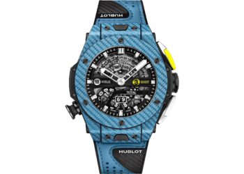 A blue Hublot wristwatch with a skeleton dial, black strap, and visible mechanical components stands out among the best luxury watches, featuring specialized markers and a distinctive yellow accent button.