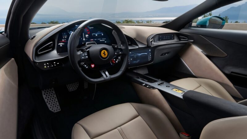 The image shows the modern interior of a luxury sports car, likely a Ferrari Roma facelift, with a Ferrari logo on the steering wheel, digital displays, leather seats, and a coastal view visible through the windows.