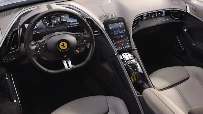Interior view of a Ferrari Amalfi sports car showing the steering wheel, digital dashboard, touchscreen center console, and leather seats—a striking update highlighted in recent Ferrari News.