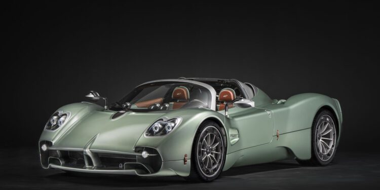 A matte sage green Pagani sports car with a convertible roof, silver wheels, distinctive headlights, and brown leather seats, photographed in a studio with a black background—ready for the hillclimb runs at Goodwood FoS 2025.