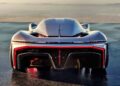 A sleek silver hypercar viewed from the rear, showcasing aerodynamic curves, wide tires, and distinctive red LED taillights—a true California Corvette: GM's Pasadena Studio showcases this one-off hypercar concept against a distant landscape backdrop.