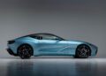 A light blue Aston Martin DBS GT Zagato with a sleek, aerodynamic design is parked indoors against a neutral background, viewed from the side—an elegant highlight from the Monterey Jet Center Auction.