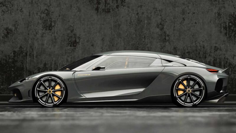A sleek, metallic grey sports car with gold accents—one of the most powerful production cars for 2025—is parked on a smooth surface in front of a textured, dark wall.