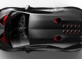 Top view of the only street-legal Lamborghini Sesto Elemento wows Goodwood—a sleek, black sports car with red accents, hexagonal rear air vents, and an exposed engine visible through the rear window.