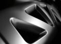 Close-up of a metallic surface with geometric cutouts and a textured, carbon fiber-like pattern reminiscent of the Only Street-Legal Lamborghini Sesto Elemento that wows at Goodwood.