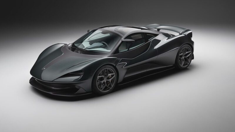 A sleek black supercar inspired by the Lanzante 95-59, with aerodynamic curves and low-profile tires, is parked in a studio with a plain background, evoking the spirit of Le Mans legends like the McLaren F1 GTR.