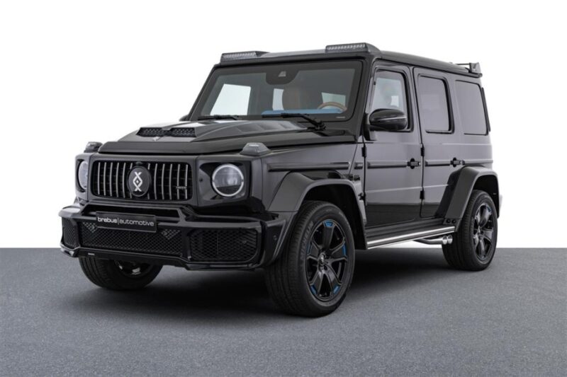 A black, customized Mercedes-Benz G-Class SUV is parked on a gray surface with a white background, showcasing a unique creation perfect for those seeking custom cars for sale.