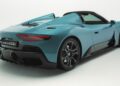 Rear view of a blue 2026 Maserati MCPURA Debuts at Goodwood with Liquid Crystal Roof and F1 tech, roof down, showcasing its aerodynamic design, rear lights, and black detailing against a white background.