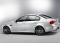 A silver BMW E90 M3 collector car is photographed from the side against a plain, light grey background.