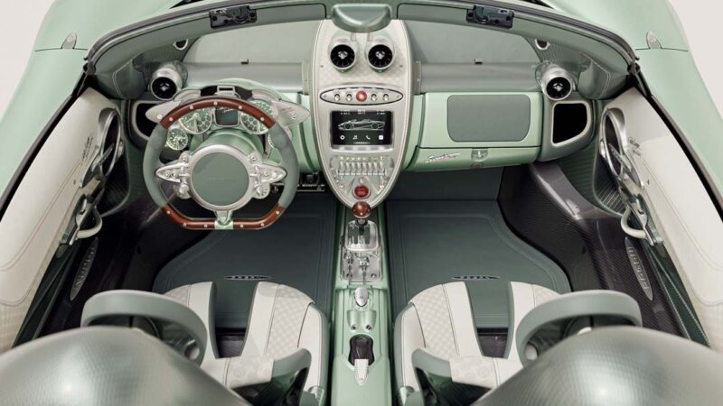 Luxury car interior featuring green leather seats, a wooden-trimmed steering wheel, and a central control panel with metallic accents—exemplifying the craftsmanship of the limited edition Pagani Huayra Codalunga by Pagani Automobili.