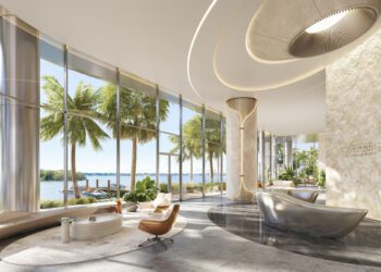 Modern lobby with large windows, palm trees outside, contemporary seating, and sleek architectural details; “Pagani Residences” logo on stone wall.