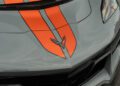 Close-up of a 2025 Chevrolet Corvette ZR1 hood featuring orange racing stripes, a Corvette emblem, and boasting 1064HP.