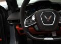 Close-up view of a 2025 Chevrolet Corvette ZR1 steering wheel with black and orange interior accents, dashboard display, and control buttons visible—showcasing the impressive 064HP performance, now available for sale.