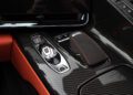 Close-up of the 2025 Chevrolet Corvette ZR1’s center console, for sale, featuring a gear selector, drive mode buttons, and a leather-trimmed touchpad with carbon fiber and orange stitching details—highlighting its powerful 864HP performance.