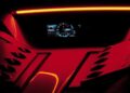 Close-up of a car’s illuminated digital dashboard and instrument cluster with red accent lighting, featuring the Porsche logo on both sides—a nod to the Carrera GT tribute capsule collection.