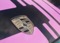 Close-up of a Porsche emblem on a car hood with a black and pink geometric paint design, echoing the style Richard Hammond shares why he loves the Porsche 911.