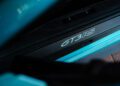 Close-up view of a car door sill with "GT3 RS" lettering on a carbon fiber plate, alongside a striking PTS Ipanema Blue 911 GT3 RS from Porsche Exchange.