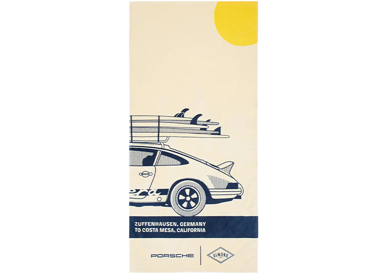 Illustration of a classic Porsche car with Almond Surfboards single fins on the roof, a yellow sun in the corner, and text reading "Zuffenhausen, Germany to Costa Mesa, California.