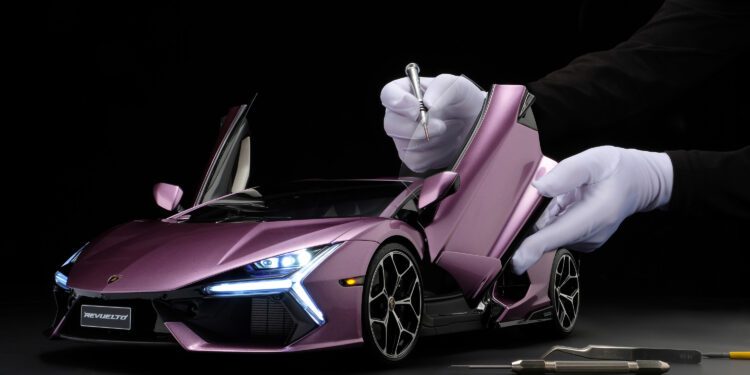 A person in white gloves uses tools to work on a detailed purple Lamborghini Revuelto model with open doors against a black background.
