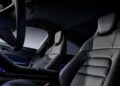 Black Edition black leather front seats and dashboard of a 2026 Taycan interior with embossed headrests, shown from the passenger side—pure Porsche luxury.