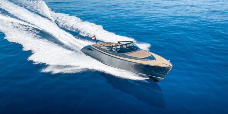 A modern luxury yacht moves quickly across calm, deep blue water, leaving a white trail behind it and showcasing the ultimate maritime experience.
