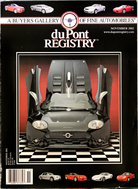 DuPont REGISTRY magazine’s November 2002 cover features a Spyker C8 Spyder with its doors open, showcased on a checkered floor. Above and below are images of Cover Cars and signature magazine branding celebrating automotive excellence.
